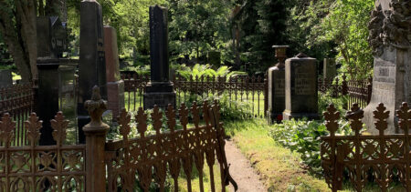 Raninien sukuhauta Isolla hautausmaalla, rauta-aidat reunustavat hautaa varjoisalla hautausmaalla.