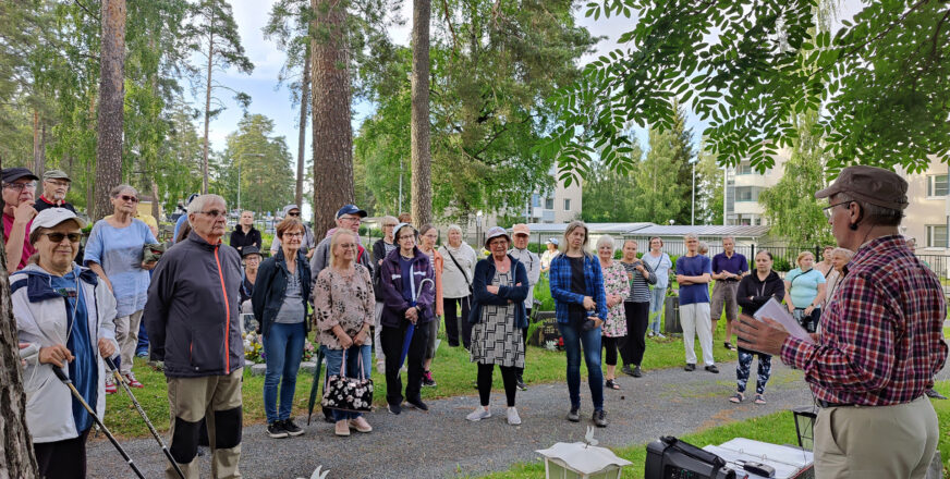 hautausmaakävely Viinamäenhautausmaalla. Ihmiset ovat kerääntyneet ohjaajan ympärille kuulemaan tarinaa